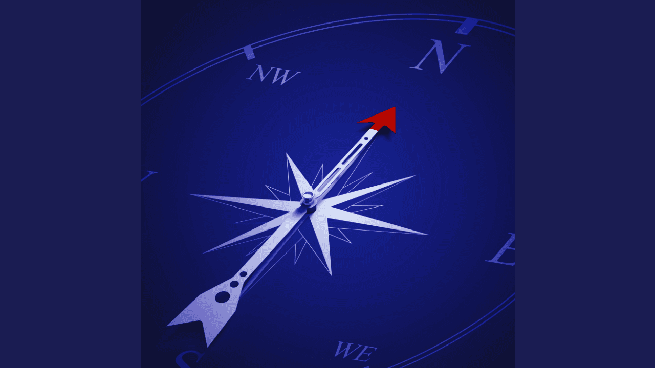 A blue compass with a red-tipped needle pointing towards the North direction indicator.